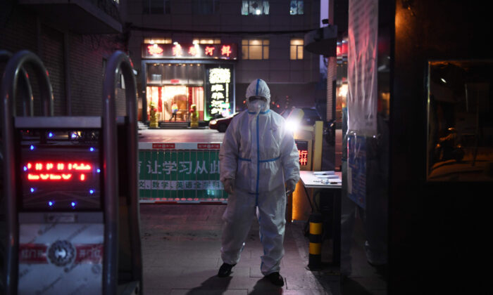 A security guard wears protective clothing as a preventive measure against the COVID-19 coronavirus as he stands at the entrance of a restaurant in Beijing on Feb. 25, 2020. (Greg Baker/AFP via Getty Images)