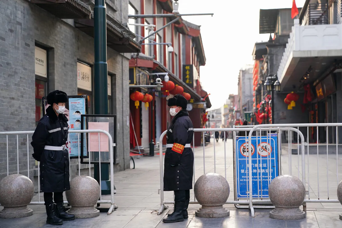 Chinese security guards wear protective masks as they stand on an empty commercial street on Feb. 25, 2020 in Beijing, China. (Lintao Zhang/Getty Images)
