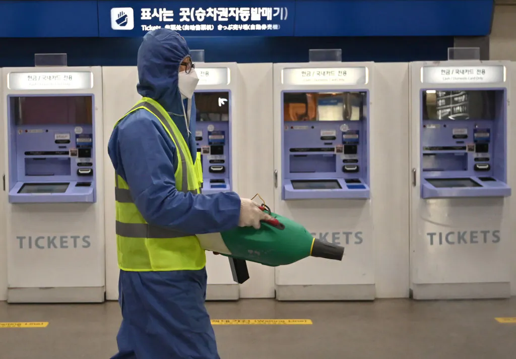 A worker wearing protective gear sprays disinfectant as part of preventive measures against the spread of the novel coronavirus at a railway station in Daegu, South Korea, on Feb. 26, 2020. (Jung Yeon-je/AFP via Getty Images)