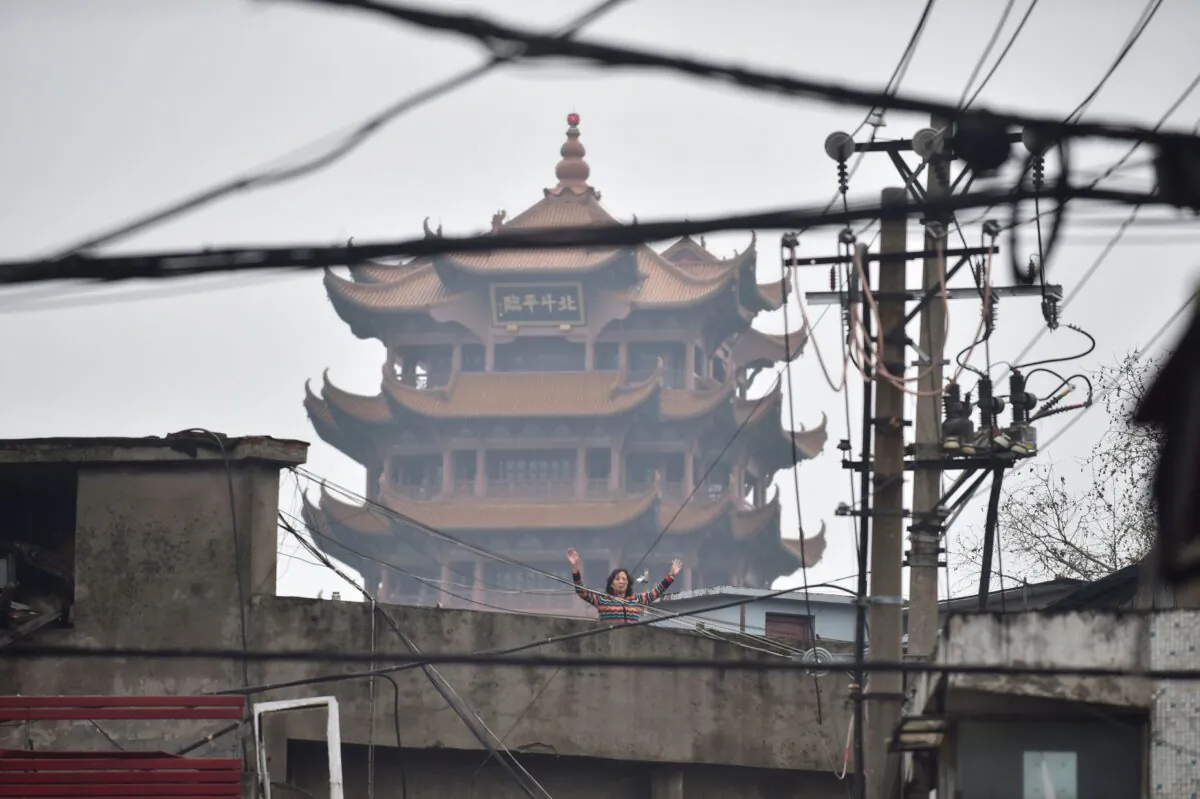 A woman is doing exercises on a rooftop in Wuhan, China on Feb. 26, 2020. (STR/AFP via Getty Images)