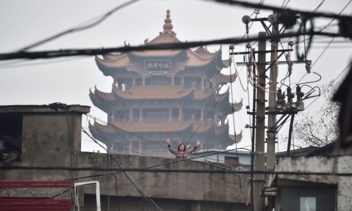 A woman is doing exercises on a rooftop in Wuhan, China on Feb. 26, 2020. (STR/AFP via Getty Images)