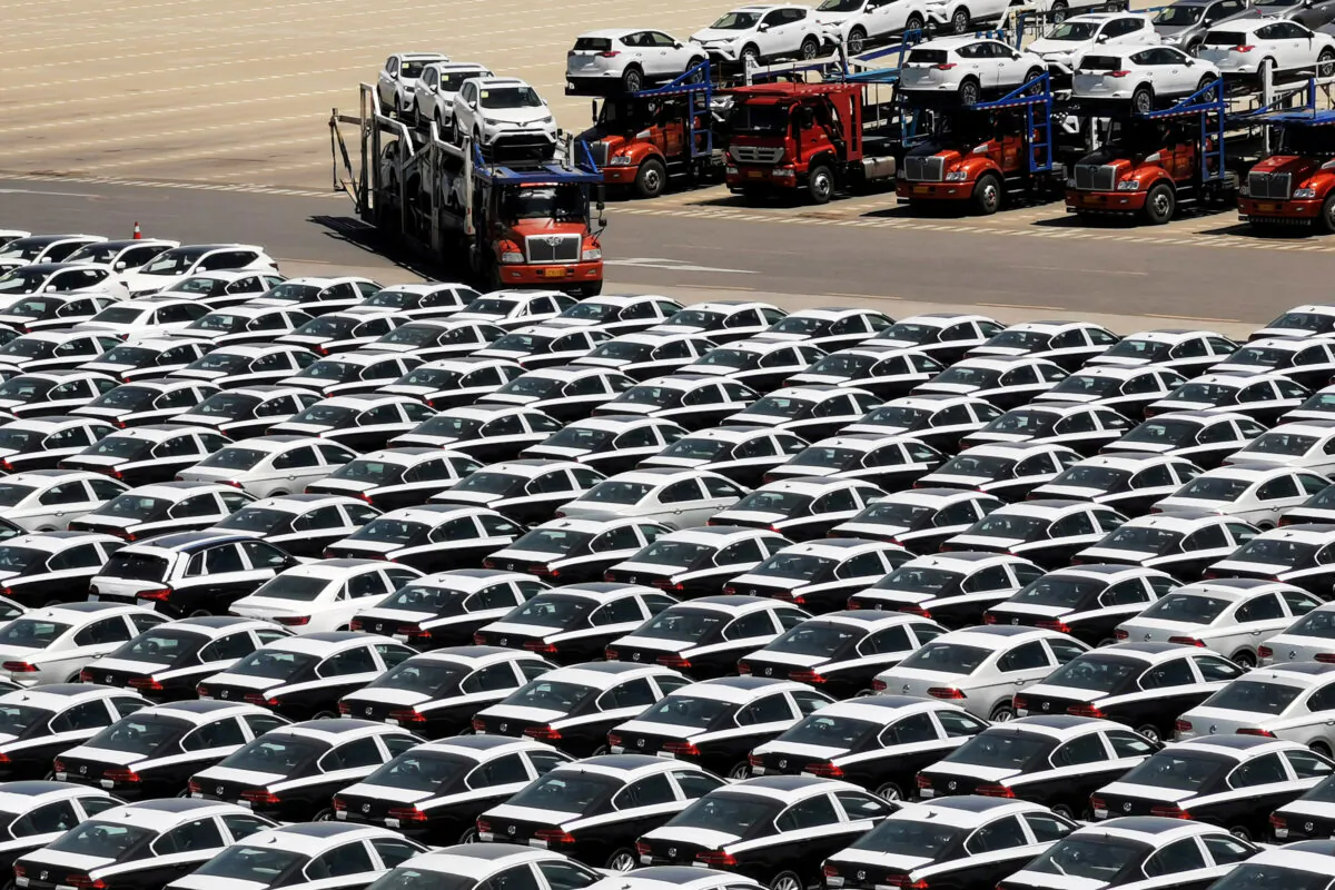 A carrier trailer transports newly manufactured cars at a port in Dalian, Liaoning Province, China on May 21, 2019. (Reuters)