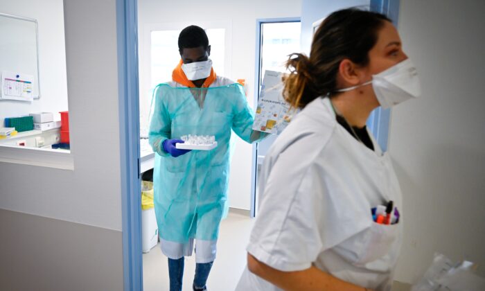 Medical staff work in the laboratory to analyze samples on the possible presence of COVID-19 in a file photo. (Gerard Julien/AFP via Getty Images)