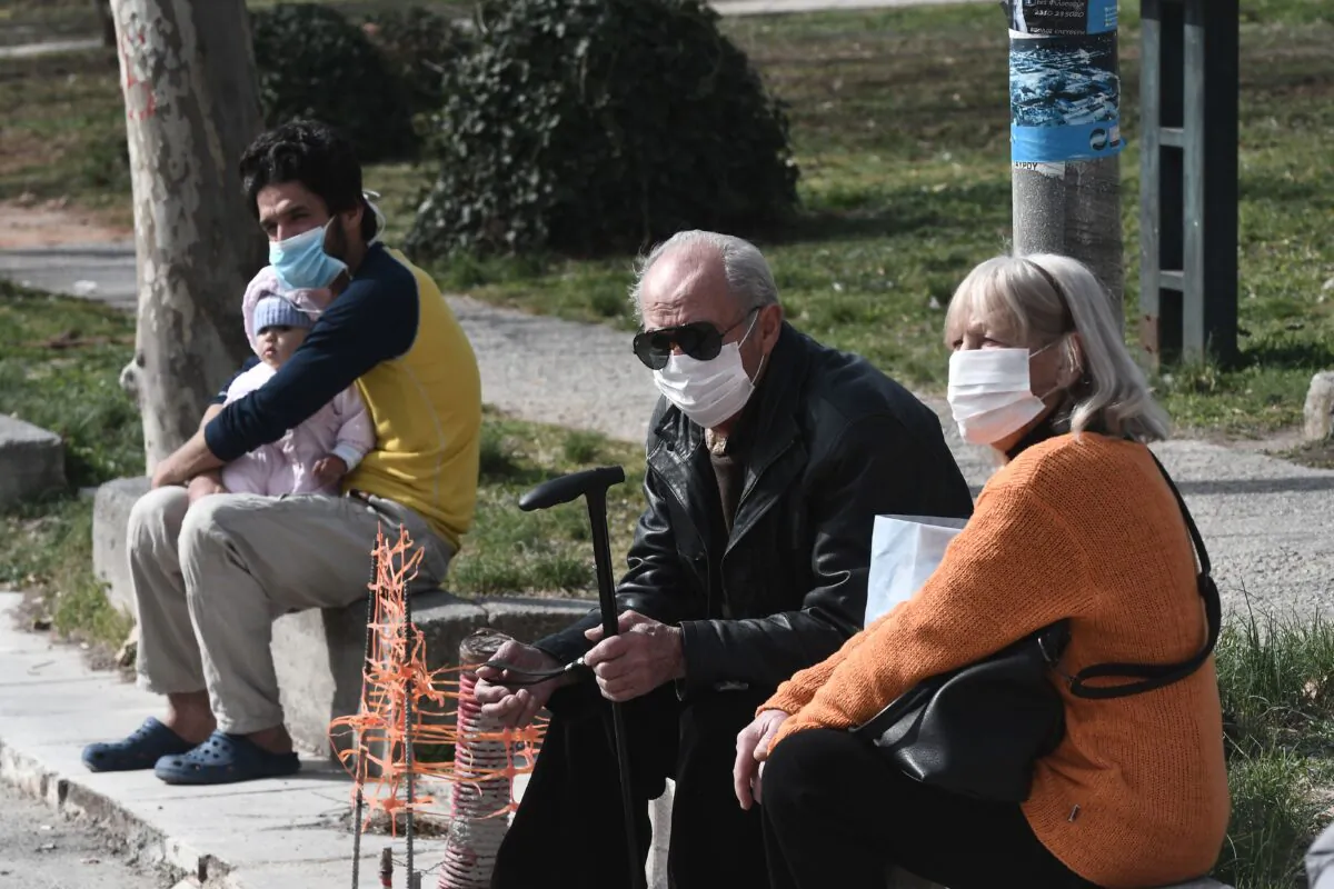 People with face masks sit outside of the hospital of Ahepa in Thessaloniki on Feb. 26, 2020, the same day the country reported its first case of the new coronavirus. (Sakis Mitrolidis/AFP via Getty Images)