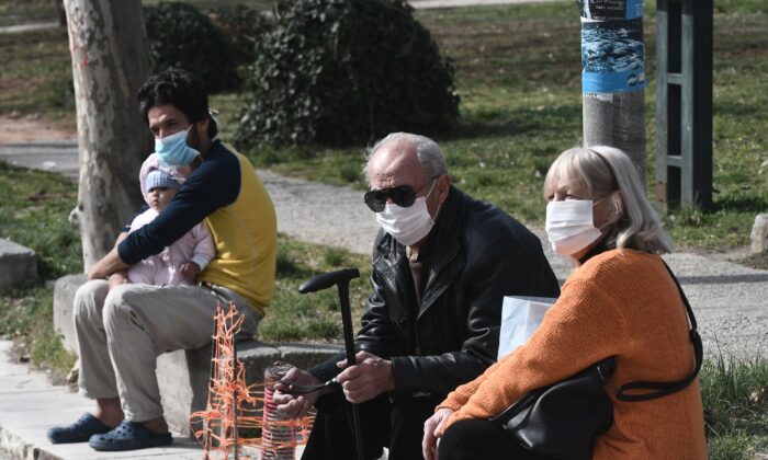 People with face masks sit outside of the hospital of Ahepa in Thessaloniki on Feb. 26, 2020, the same day the country reported its first case of the new coronavirus. (Sakis Mitrolidis/AFP via Getty Images)