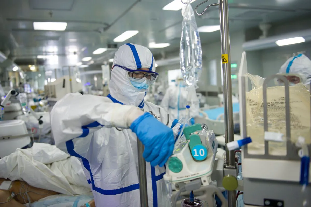 A nurse is operating an equipment in an intensive care unit treating COVID-19 coronavirus patients at a hospital in Wuhan, China, on Feb. 22, 2020. (STR/AFP via Getty Images)