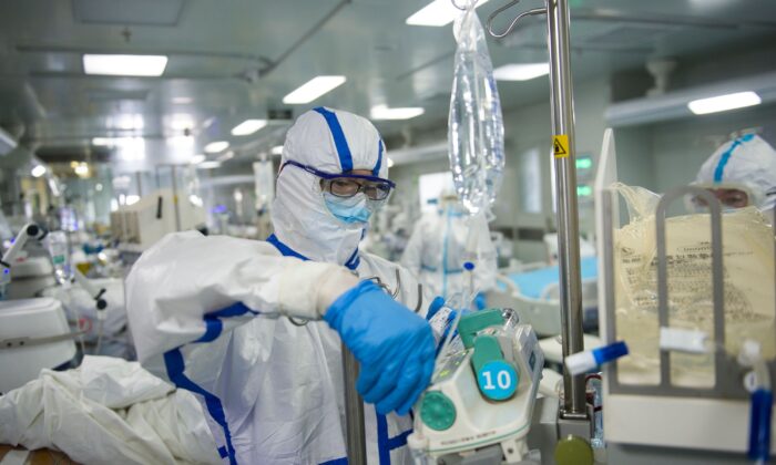 A nurse is operating an equipment in an intensive care unit treating COVID-19 coronavirus patients at a hospital in Wuhan, China, on Feb. 22, 2020. (STR/AFP via Getty Images)