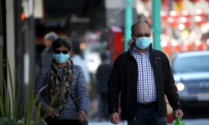 People wear surgical masks as they walk along Chinatown's Grant Avenue in San Francisco, California on Feb. 26, 2020. (Justin Sullivan/Getty Images)