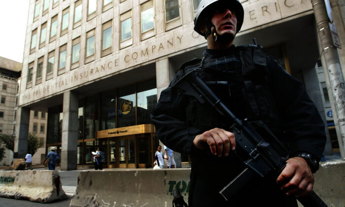 A heavily armed Newark Police officer stands guard outside the Prudential Insurance Company building in Newark, N.J., on Aug. 10, 2004. (Chris Hondros/Getty Images)