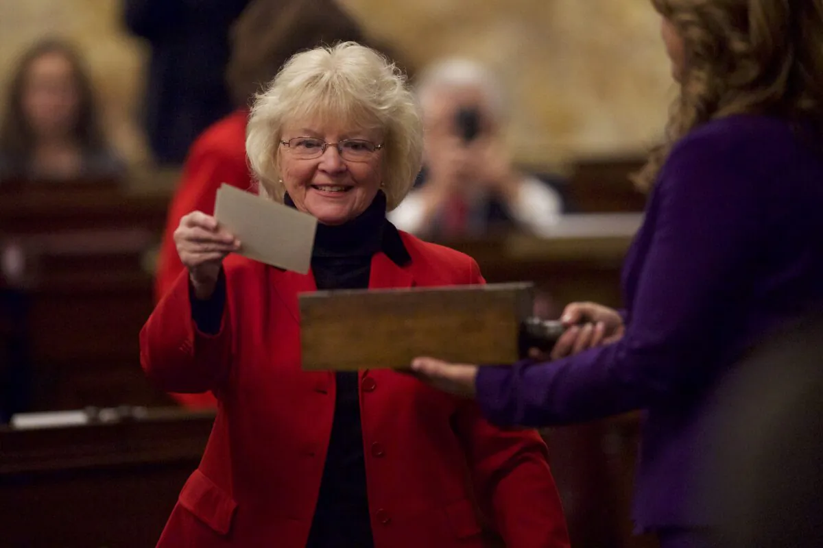 An elector places her signed ballot into a ballot box in the House of Representatives chamber of the Pennsylvania Capitol Building in Harrisburg on Dec. 19, 2016. (Mark Makela/Getty Images)