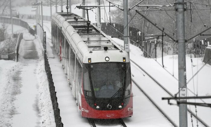 An OC Transpo LRT train heads towards Lees Station on the Confederation Line during a snowstorm in Ottawa, on Feb. 27, 2020. (Justin Tang/The Canadian Press)