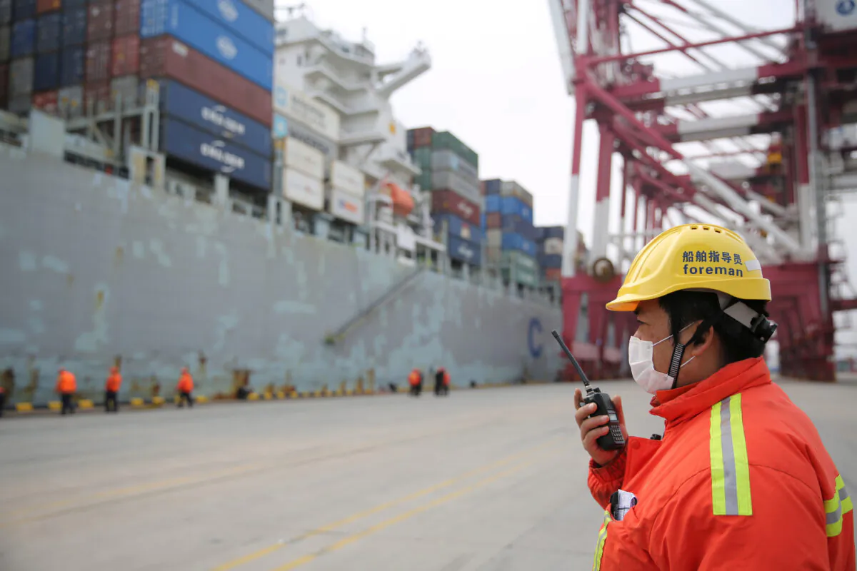 A foreman wearing a face mask works as a cargo ship docks at a container terminal of Qingdao port in Shandong Province, China while the country is hit by an outbreak of the new coronavirus, on Feb. 4, 2020. (cnsphoto via Reuters)