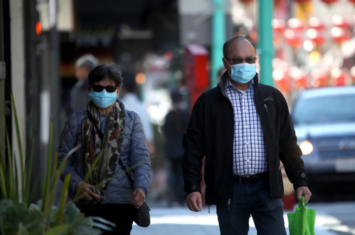 People wear surgical masks as they walk along Chinatown's Grant Avenue in San Francisco on Feb. 26, 2020. (Justin Sullivan/Getty Images)