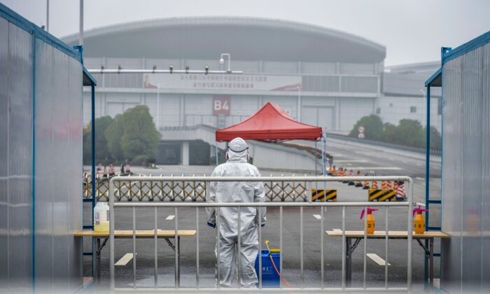 A medical staff wearing protective gear looking on outside a makeshift hospital in Wuhan in China's central Hubei province. - Chinese authorities on February 24 slightly relaxed their month-long quarantine measures in Wuhan, allowing some people to leave the epicentre of the country's virus epidemic under certain conditions, on Feb. 22, 2020. (STR/AFP via Getty Images)