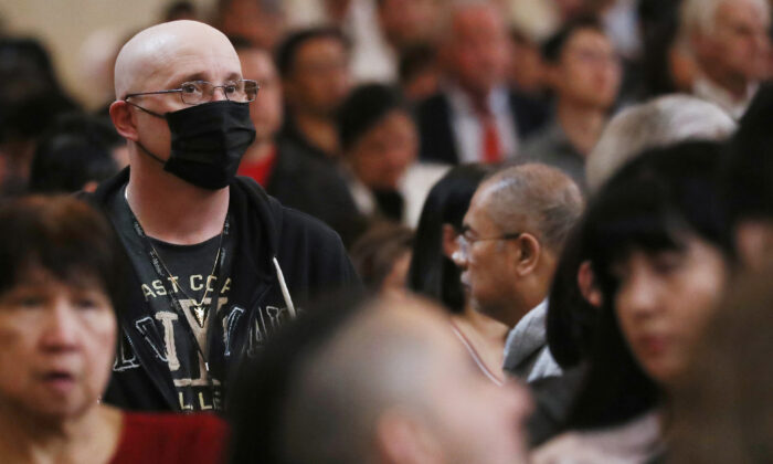 A worshipper (L) wears a face mask to protect against the coronavirus while sitting in a pew at the Cathedral of Our Lady of the Angels on Ash Wednesday on Feb. 26, 2020 in Los Angeles, Calif. (Mario Tama/Getty Images)