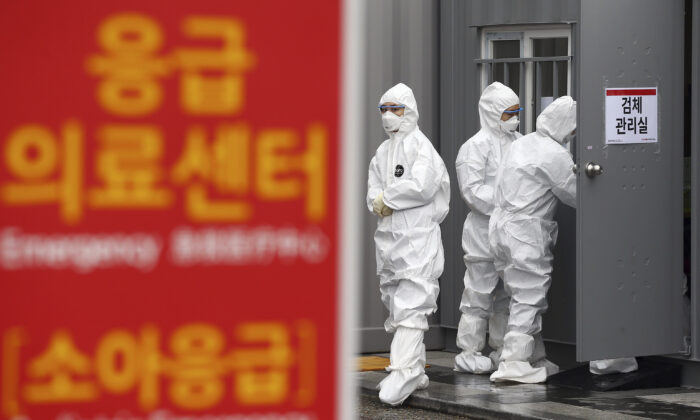 Officials wearing protective attire work to diagnose people with suspected symptoms of the new coronavirus at a hospital in Daegu, South Korea, on Feb. 26, 2020. (Kim Hyun-tae/Yonhap via AP)