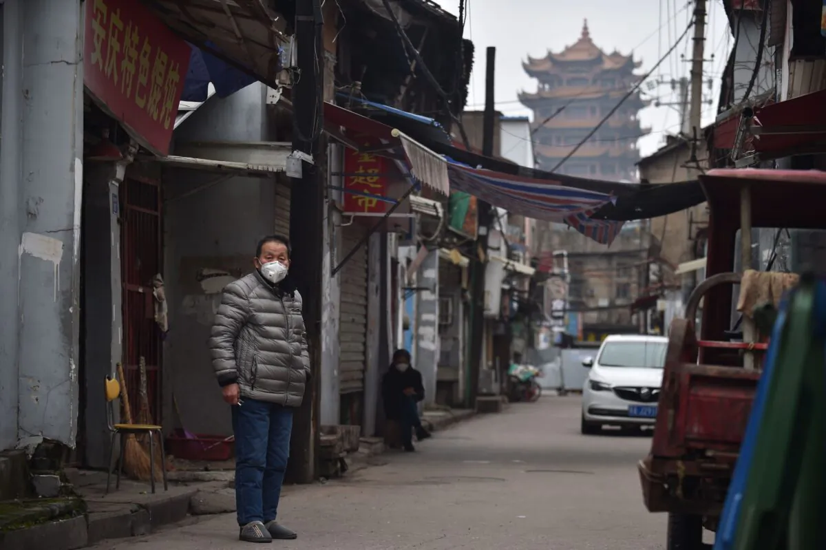 A man wears a face mask as a preventive measure against the COVID-19 coronavirus in an alley in Wuhan, in China's central Hubei Province, on Feb. 26, 2020. (STR/AFP via Getty Images)