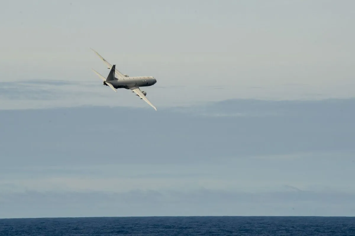 A P-8A Poseidon assigned to the Golden Swordsmen of Patrol Squadron (VP) 47 performs a fly-by next to the Arleigh Burke-class guided-missile destroyer USS Preble (DDG 88). (U.S. Navy photo by Mass Communication Specialist 1st Class Bryan Niegel)
