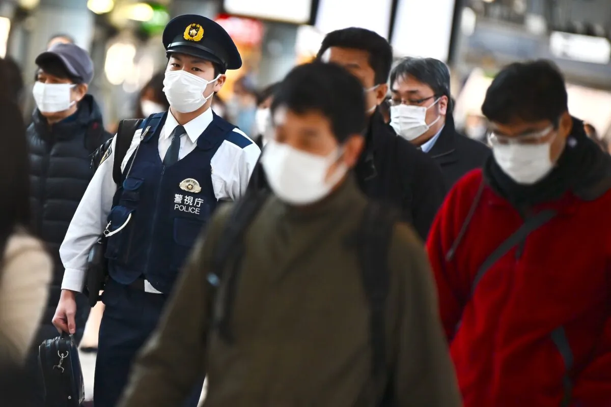 Mask-clad commuters make their way to work during morning rush hour at the Shinagawa train station in Tokyo on Feb. 28, 2020. (Charly Triballeau/AFP via Getty Images)