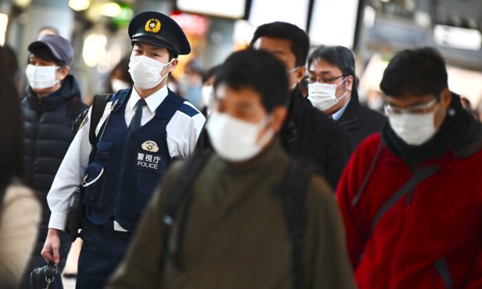 Mask-clad commuters make their way to work during morning rush hour at the Shinagawa train station in Tokyo on Feb. 28, 2020. (Charly Triballeau/AFP via Getty Images)