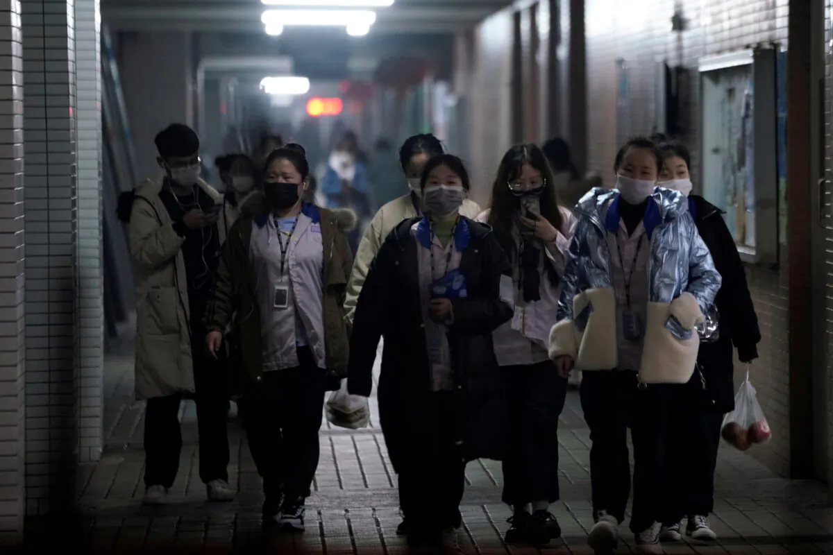 Workers wearing masks walk outside their dormitory, in an electronics manufacturing factory in Shanghai, China, as the country is hit by an outbreak of a new coronavirus, on Feb. 12, 2020. (Aly Song/Reuters)