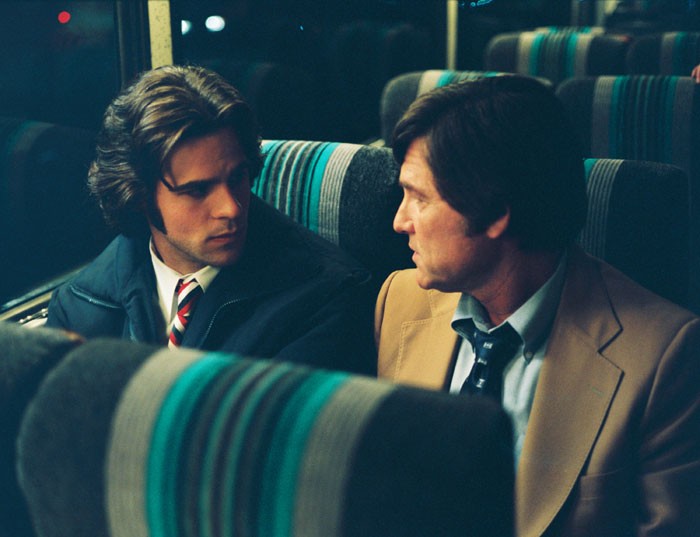 two men talk on bus