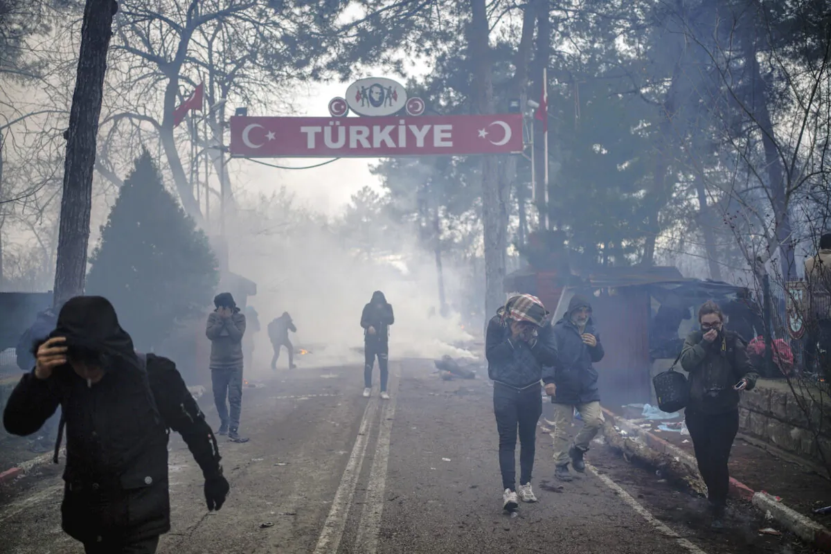 Greek border guards use tear gas to push back migrants who try to enter Greece at the Pazarkule border gate, Edirne, Turkey, on Feb. 29, 2020. (Ismail Coskun/IHA via AP)