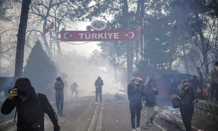 Greek border guards use tear gas to push back migrants who try to enter Greece at the Pazarkule border gate, Edirne, Turkey, on Feb. 29, 2020. (Ismail Coskun/IHA via AP)