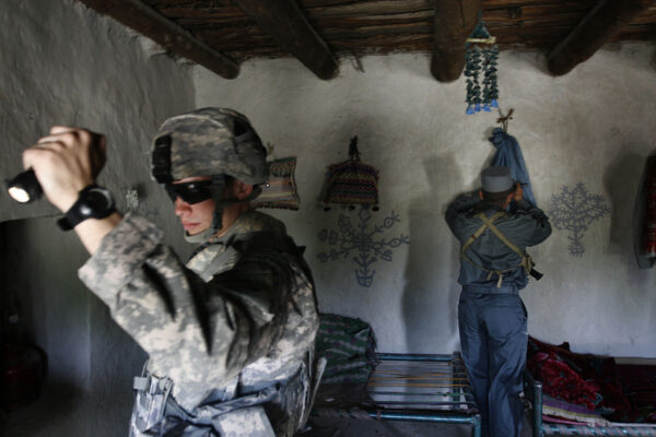 U.S. First Lt. Shane Oravsky, left, of the 101st Airborne Division searches a house