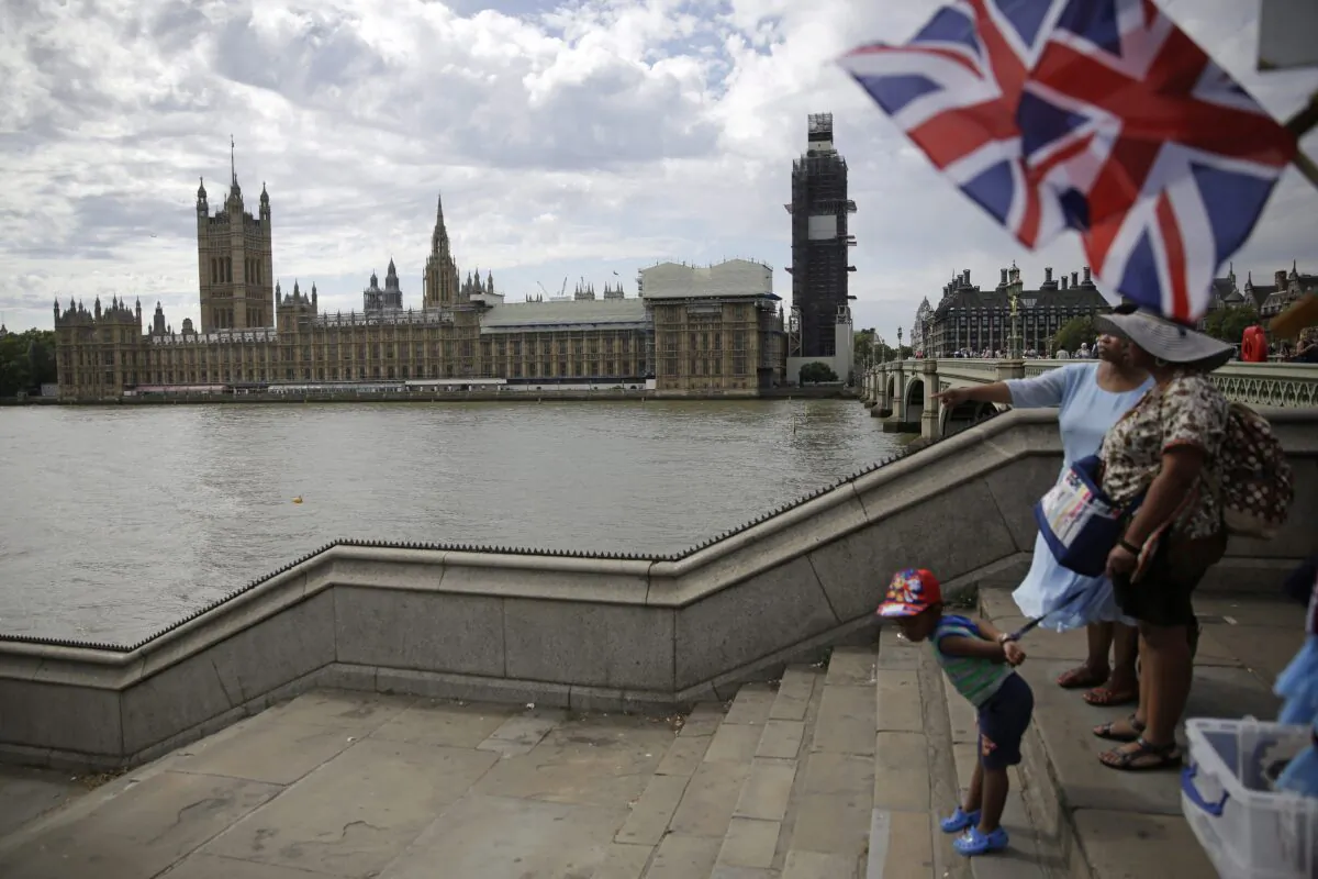 People stand on the steps to Westminster Bridge opposite the Houses of Parliament in London on Sept. 3, 2019. The weekend Britain left the EU, Conservative MP Erin O'Toole called for the implementation of CANZUK, a campaign for a new alliance between Canada, the U.K., Australia, and New Zealand. (AP Photo/Matt Dunham)