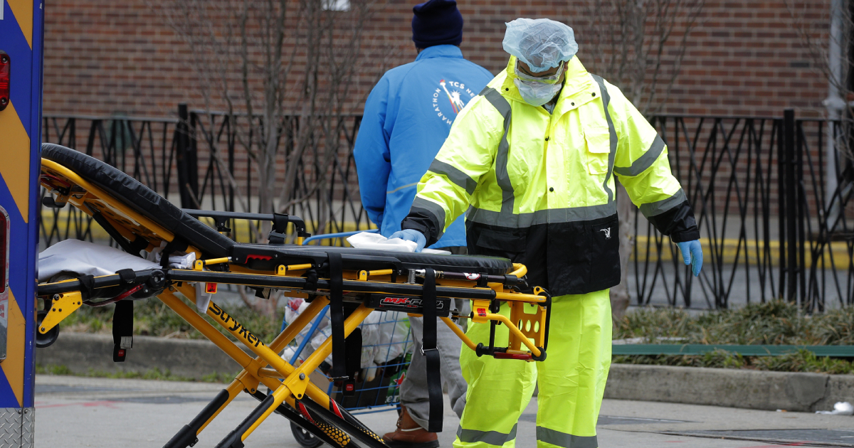 An ambulance worker sprays disinfectant