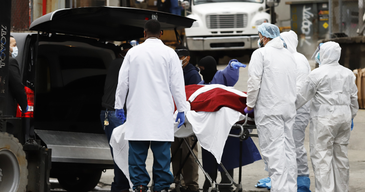 Workers load the body of a deceased person