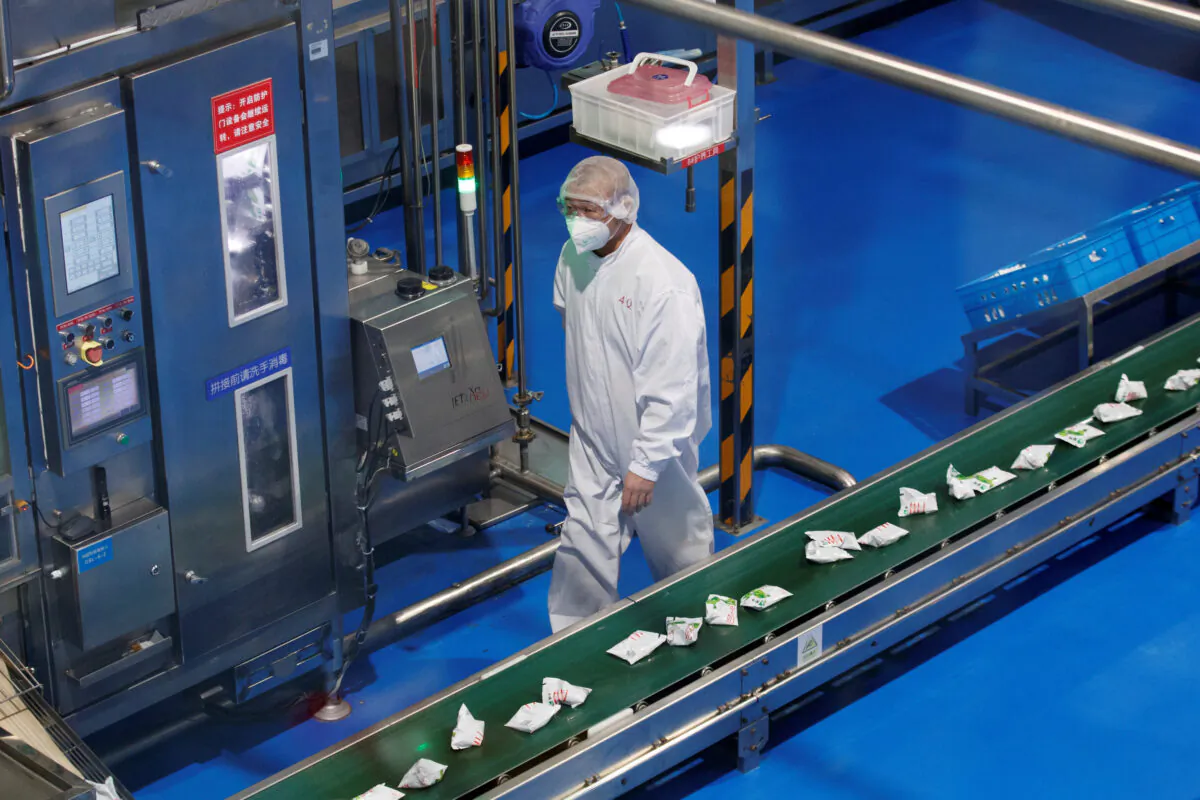 A worker wearing a face mask is seen during a government-organized tour of the Mengniu Dairy factory in Beijing as the country is hit by an outbreak of the novel coronavirus, China, on Feb. 27, 2020. (Thomas Peter/Reuters)