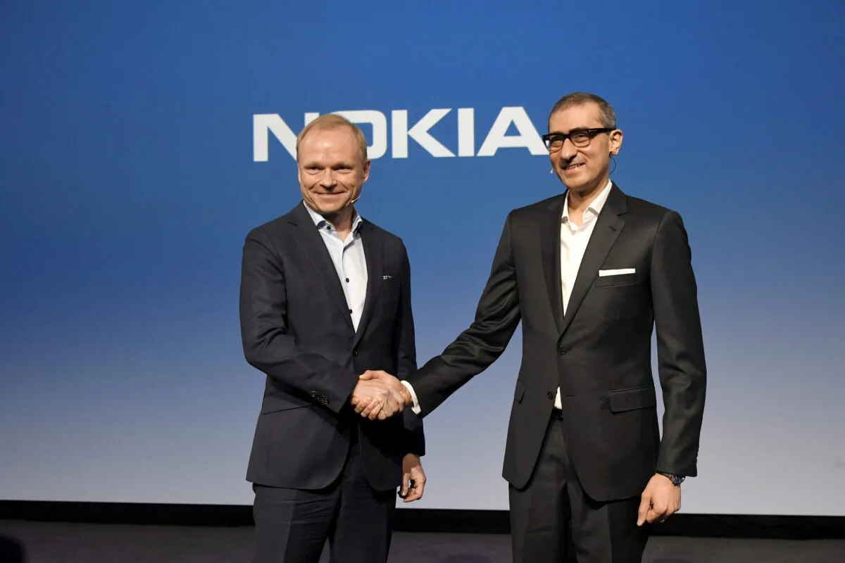 Nokia's new President and CEO Pekka Lundmark shakes hands with resigning President and CEO Rajeev Suri (R) after a news conference at the Nokia headquarters in Espoo, Finland, on March 2, 2020. (Lehtikuva/Markku Ulander via Reuters)