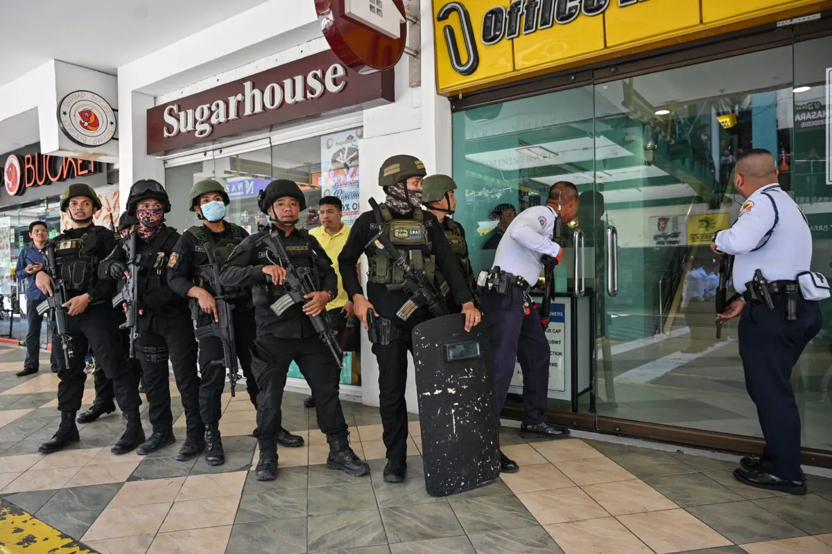 Members of a police SWAT team prepare to enter a mall after a hostage situation was reported in suburban Manila on March 2, 2020. (Photo by Ted Aljibe/AFP/Getty Images)