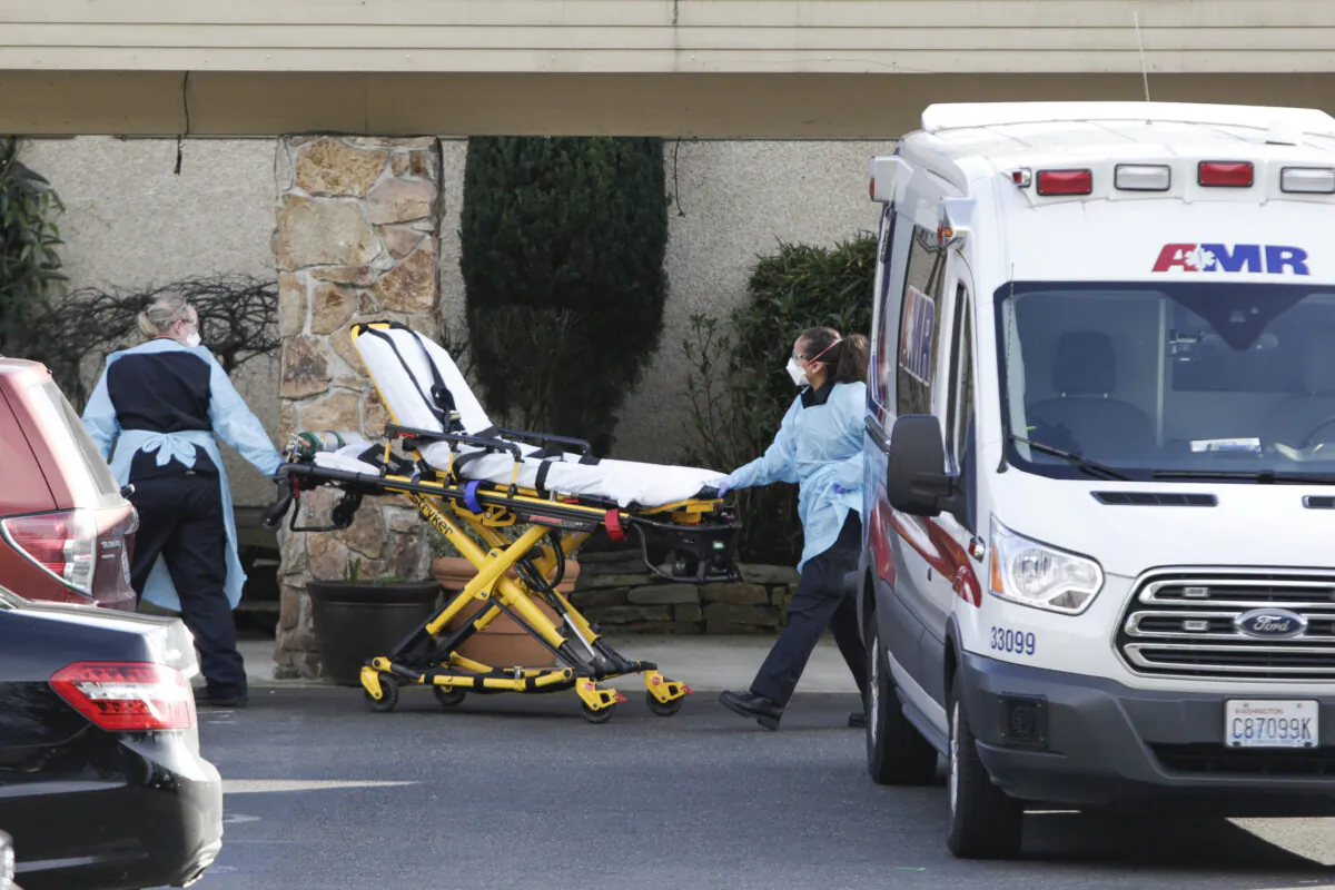 A stretcher is moved from an AMR ambulance to the Life Care Center of Kirkland, where one associate and one resident were diagnosed with COVID-19 on Feb. 29, 2020. (Jason Redmon/AFP via Getty Images)