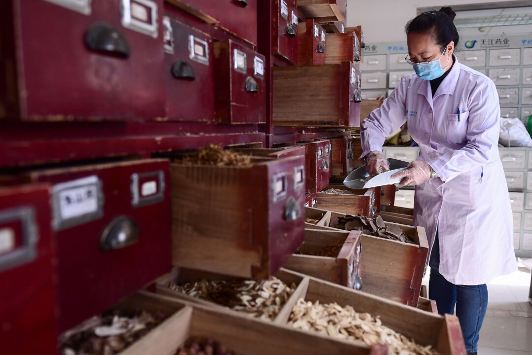 A medical worker prepares herbs according to a traditional Chinese medicine prescription at a hospital in Shenyang, China on Feb. 20, 2020. (STR/AFP via Getty Images)