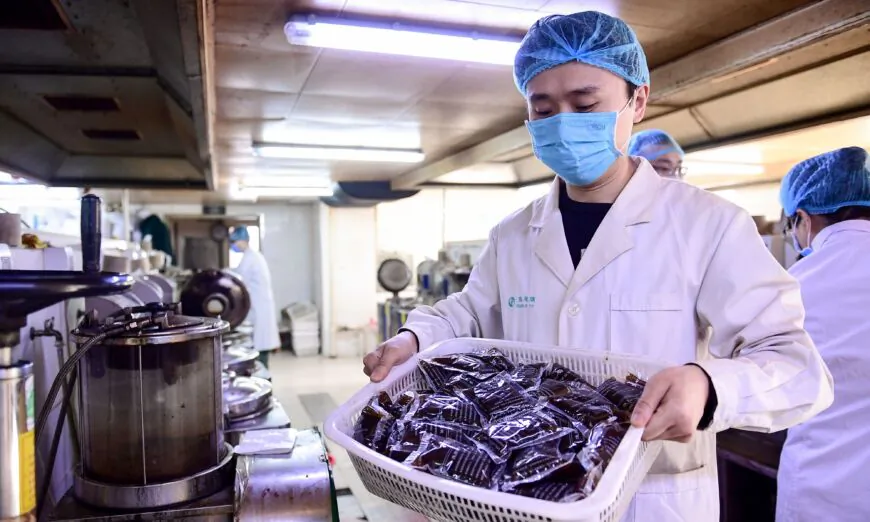 A medical worker is holding bags of liquid traditional Chinese medicine at a hospital in Shenyang, China, on Feb. 20, 2020. (STR/AFP via Getty Images)