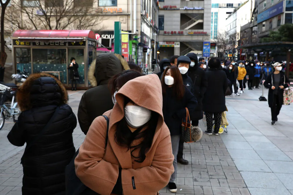 People wearing masks line up to buy face masks at a department store in Seoul on March 2, 2020. (Chung Sung-Jun/Getty Images)