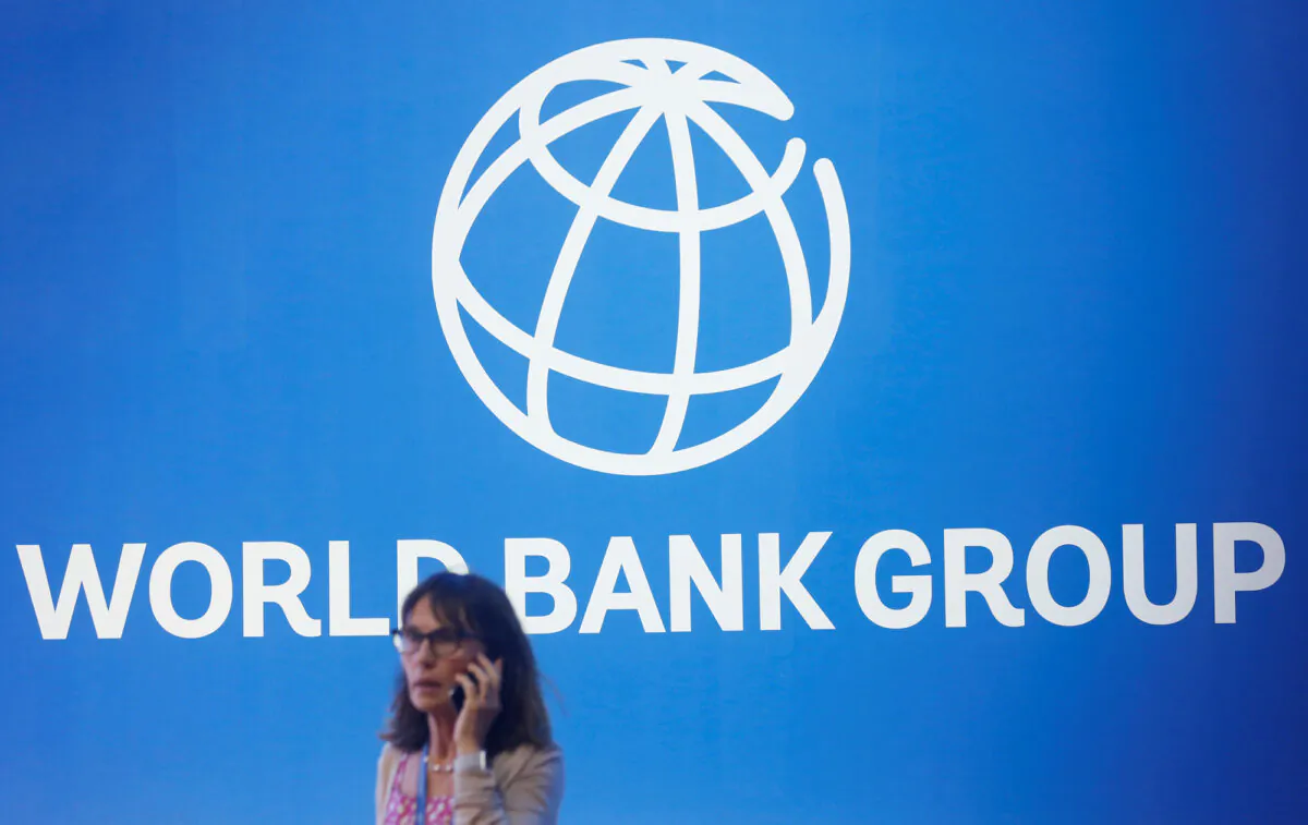 A woman stands near a logo of World Bank in Bali, Indonesia, on Oct. 12, 2018. (Johannes P. Christo/Reuters)