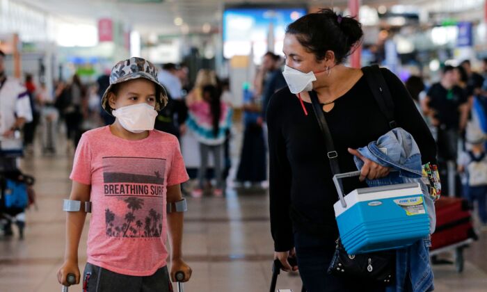 Passengers walk with protective masks at the Arturo Merino Benitez International Airport, in Santiago, on March 3, 2020. (Javier Torres/AFP via Getty Images)