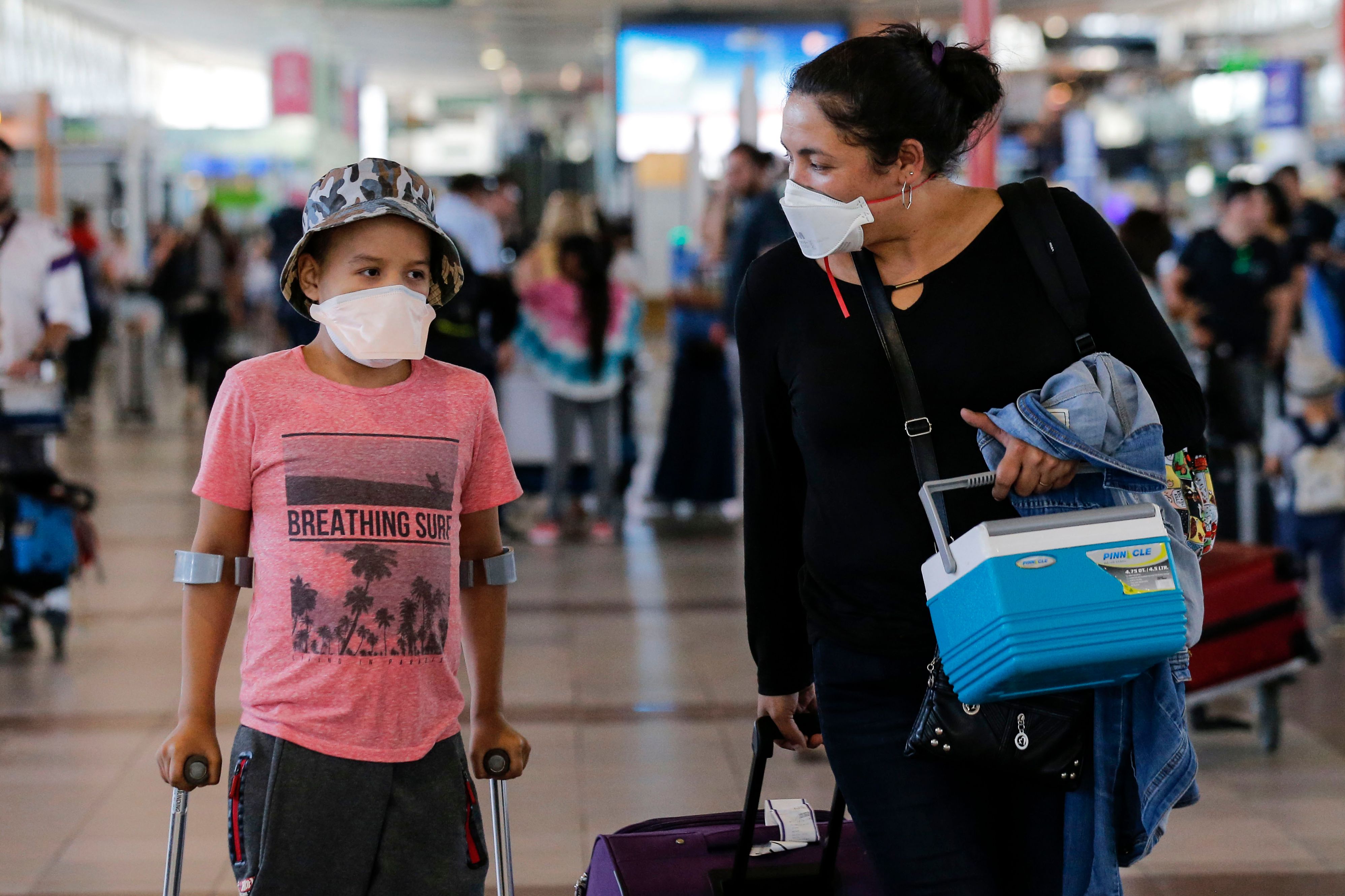 Passengers walk with protective masks