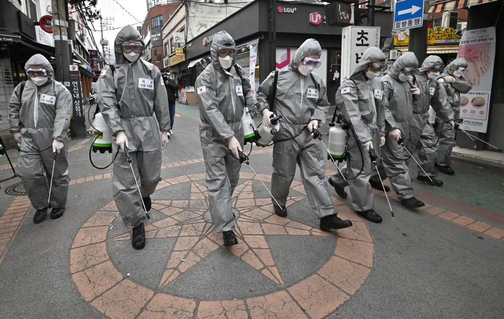 South Korean soldiers wearing protective gear spray disinfectant to help prevent the spread of the novel coronavirus at a shopping district in Seoul on March 4, 2020. (Jung Yeon-je/AFP via Getty Images)