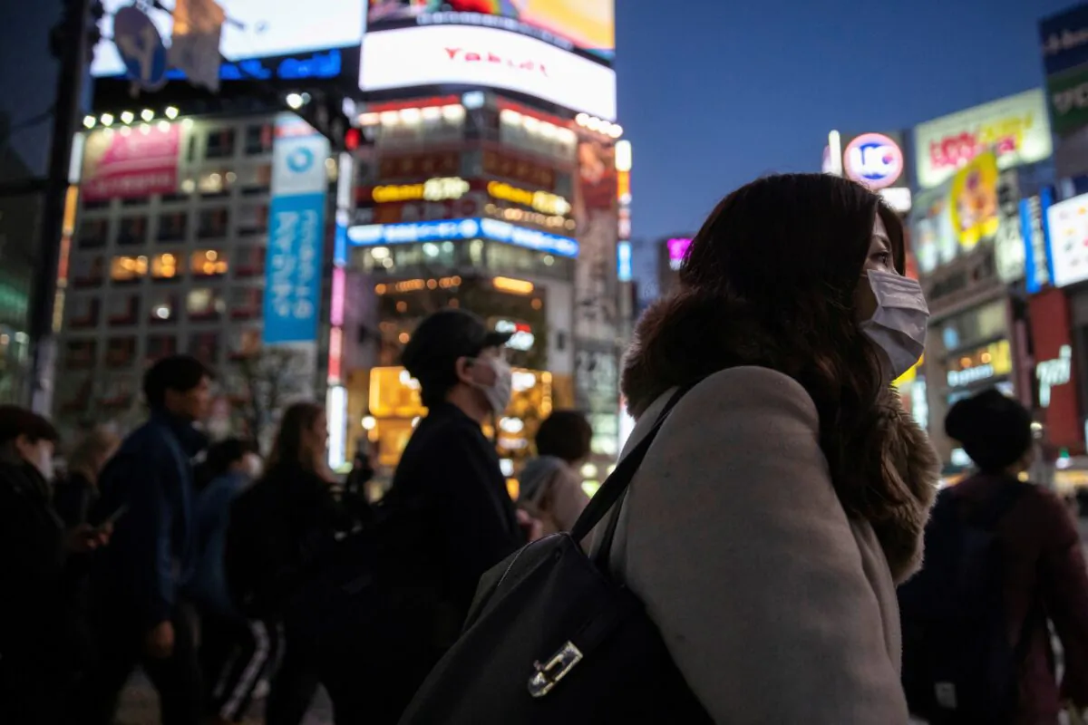 Following the outbreak of the coronavirus in Japan, a woman wearing a protective mask is seen at the scramble crossing in Shibuya shopping district in Tokyo on March 3, 2020. (Athit Perawongmetha/Reuters)