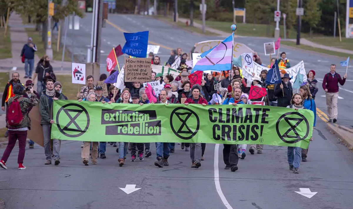 Extinction Rebellion climate activists march to the Angus L. Macdonald Bridge in Dartmouth, N.S., on Oct. 7, 2019, to block the bridge during the early morning rush hour as part of a string of protests in other Canadian cities. (The Canadian Press/Andrew Vaughan)