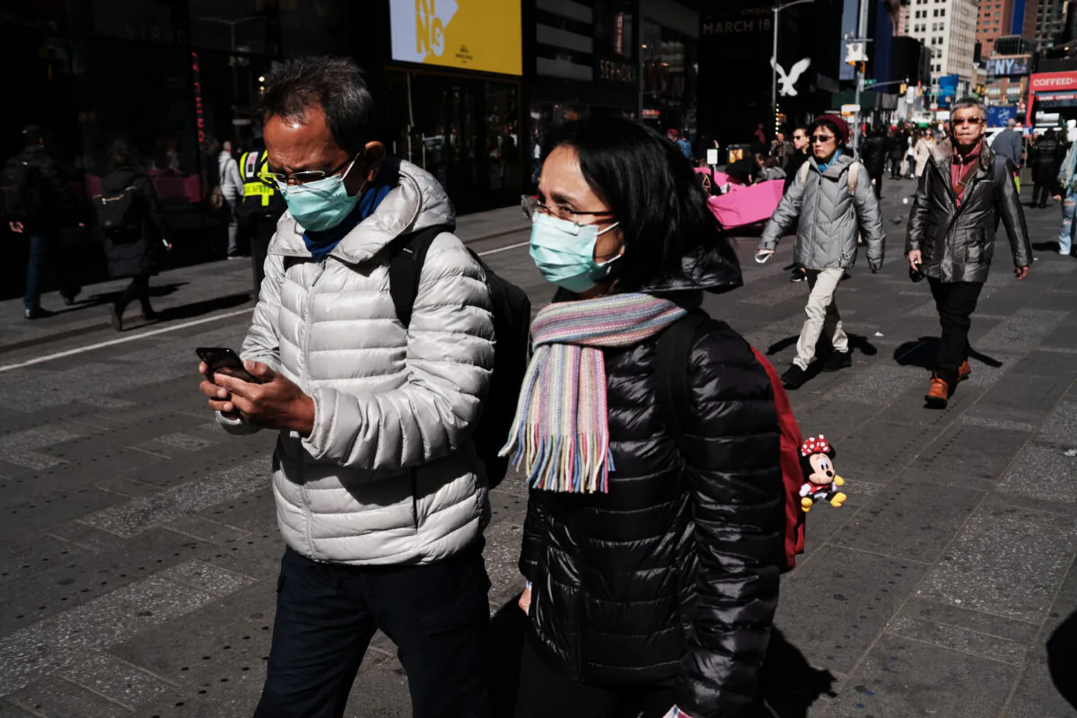 People walk through Manhattan with surgical masks as fears of the coronavirus spreading through the U.S. increase in New York City on March 4, 2020. (Spencer Platt/Getty Images)