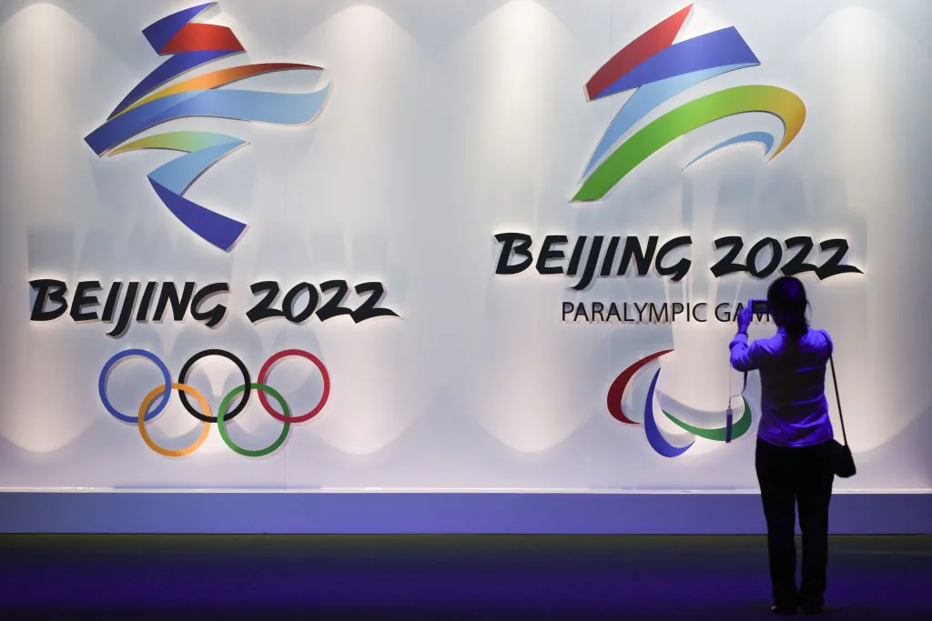 A visitor takes pictures of logos of the Beijing 2022 Winter Olympic and Paralympic Games during the Beijing Olympic Expo on Aug. 8, 2018. (Wang Zhao/AFP via Getty Images)