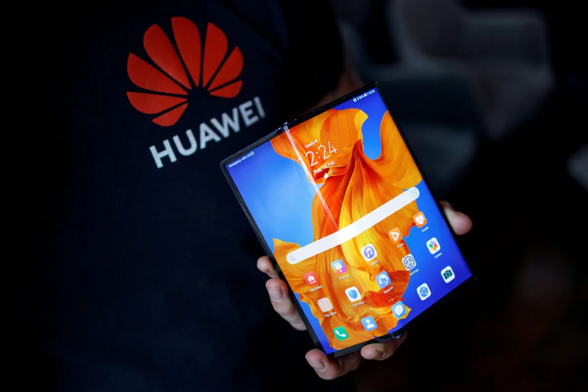 An employee displays the Huawei Mate Xs to the media during a photocall for the launch of the new foldable smartphone in London on Feb. 18, 2020. (Tolga Akmen/AFP via Getty Images)