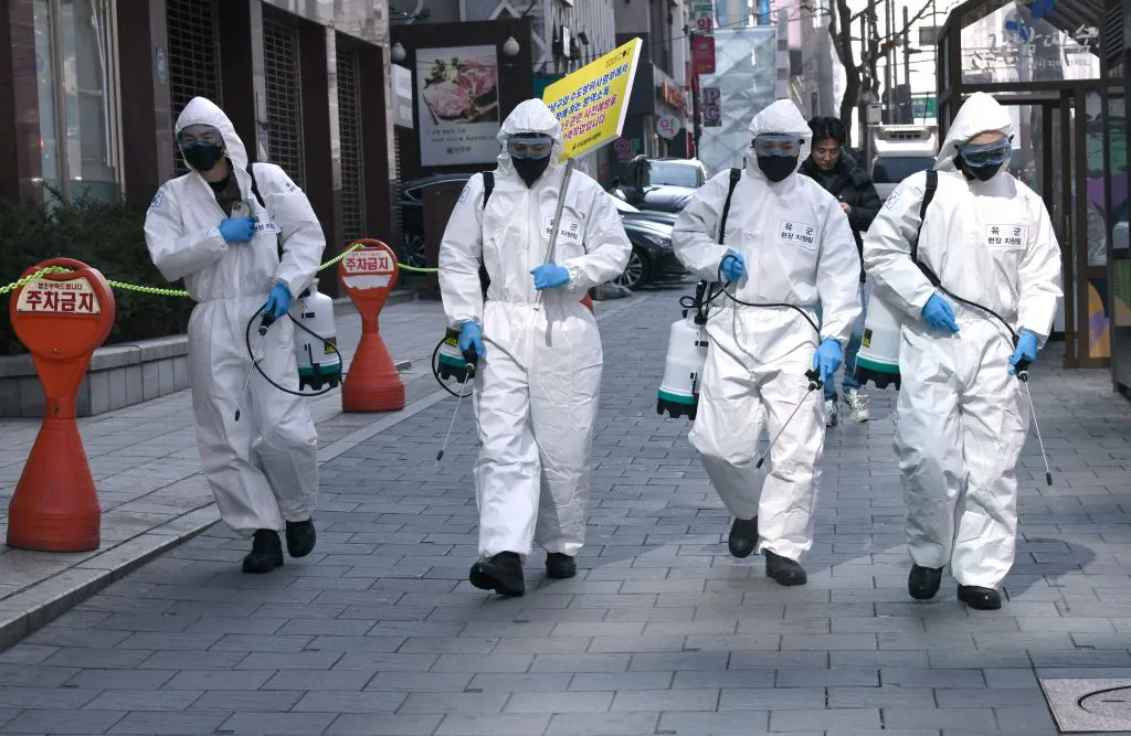 South Korean soldiers wearing protective gear spray disinfectant on the street to help prevent the spread of the novel coronavirus, at Gangnam district in Seoul on March 5, 2020. (Jung Yeon-je/AFP via Getty Images)