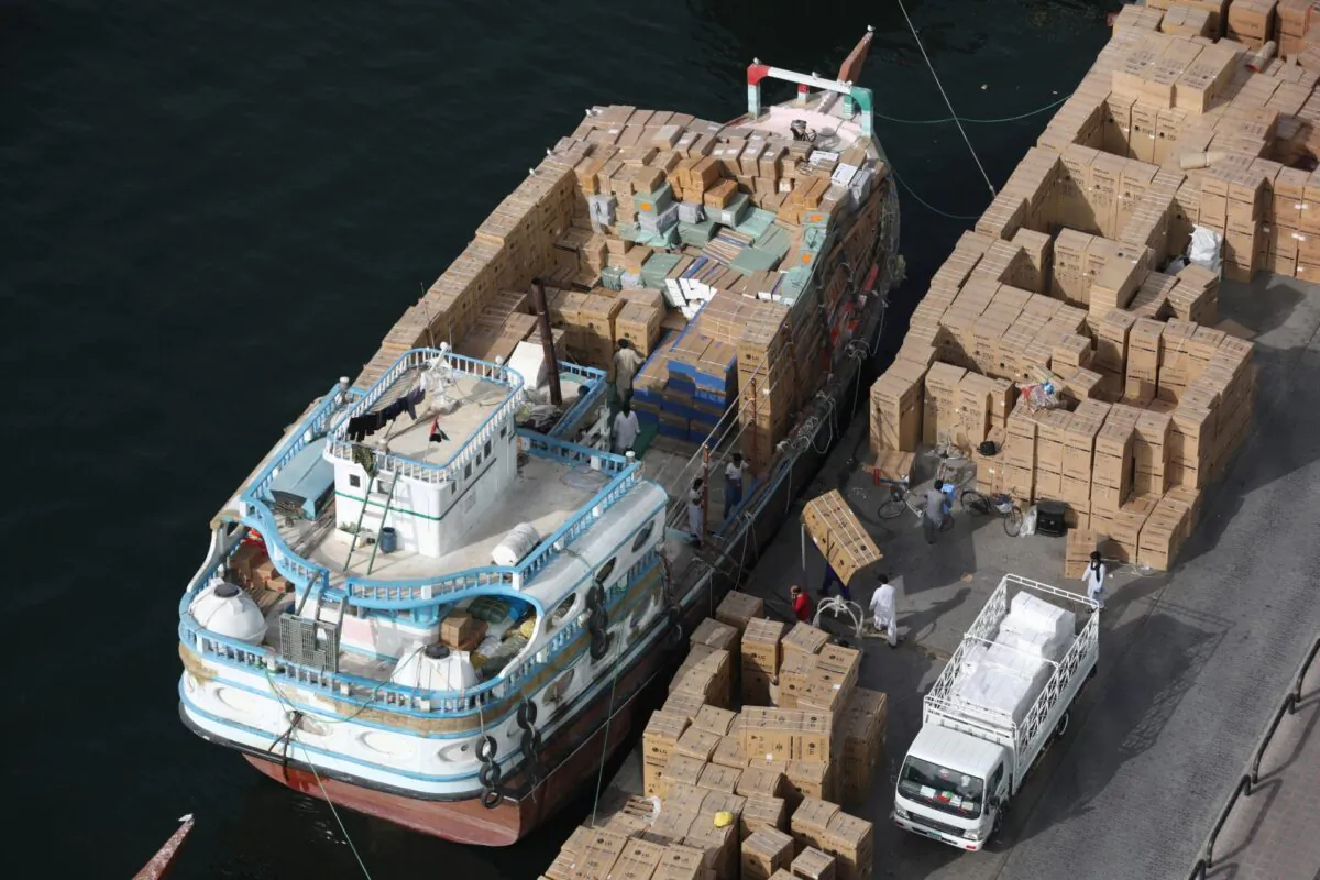 Workers load goods onto a dhow bound for Iran along the creek in old Dubai, United Arab Emirates, on March 2, 2020. (Christopher Pike/Reuters)
